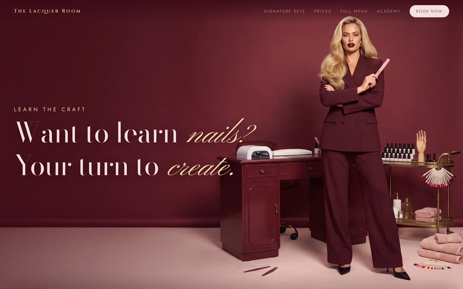 The Lacquer Room: the owner in a burgundy suit, arms crossed, nail file in hand, with the words Want to learn nails? Your turn to create.