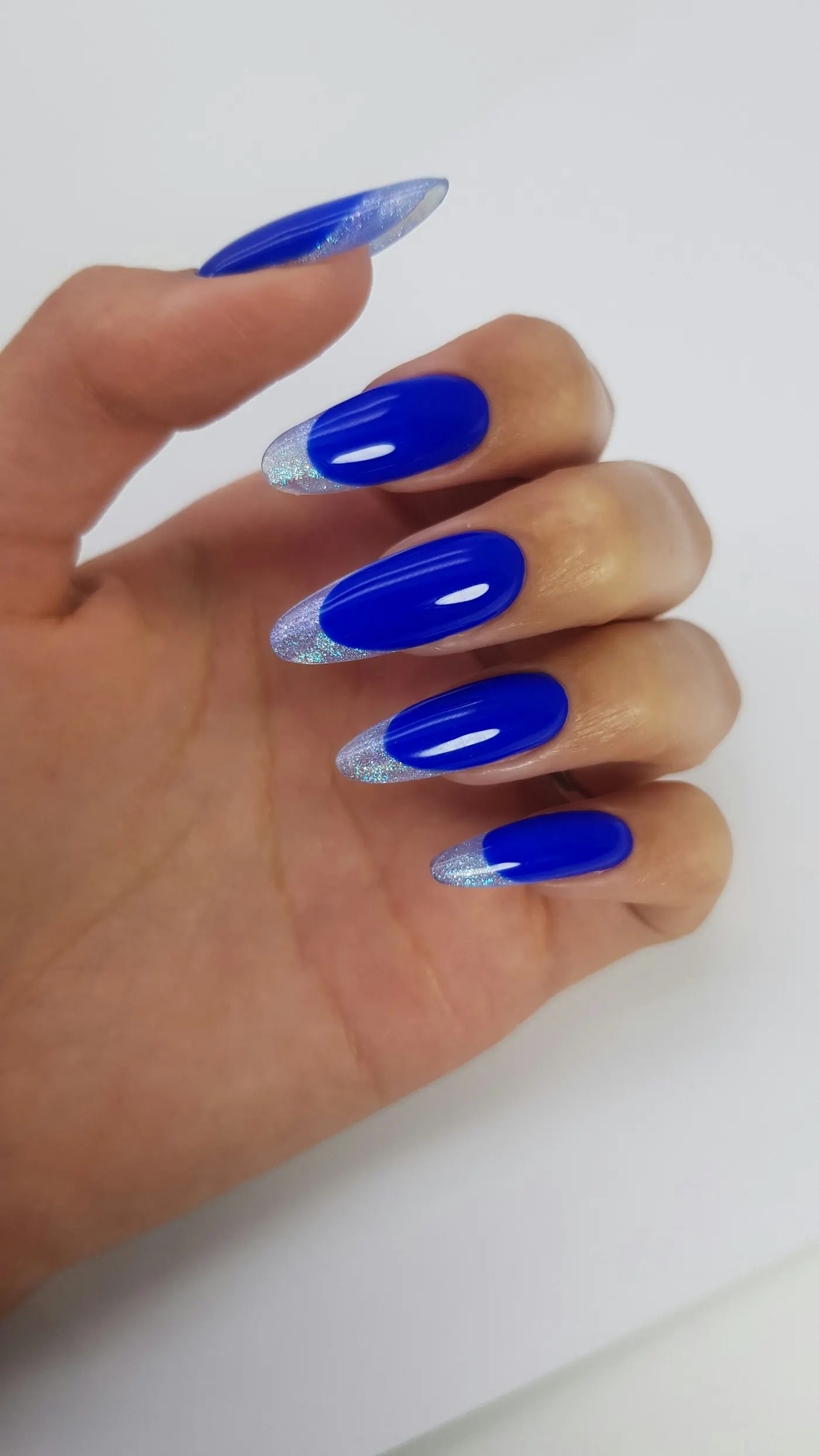 Hand with cobalt almond nails and silver French tips