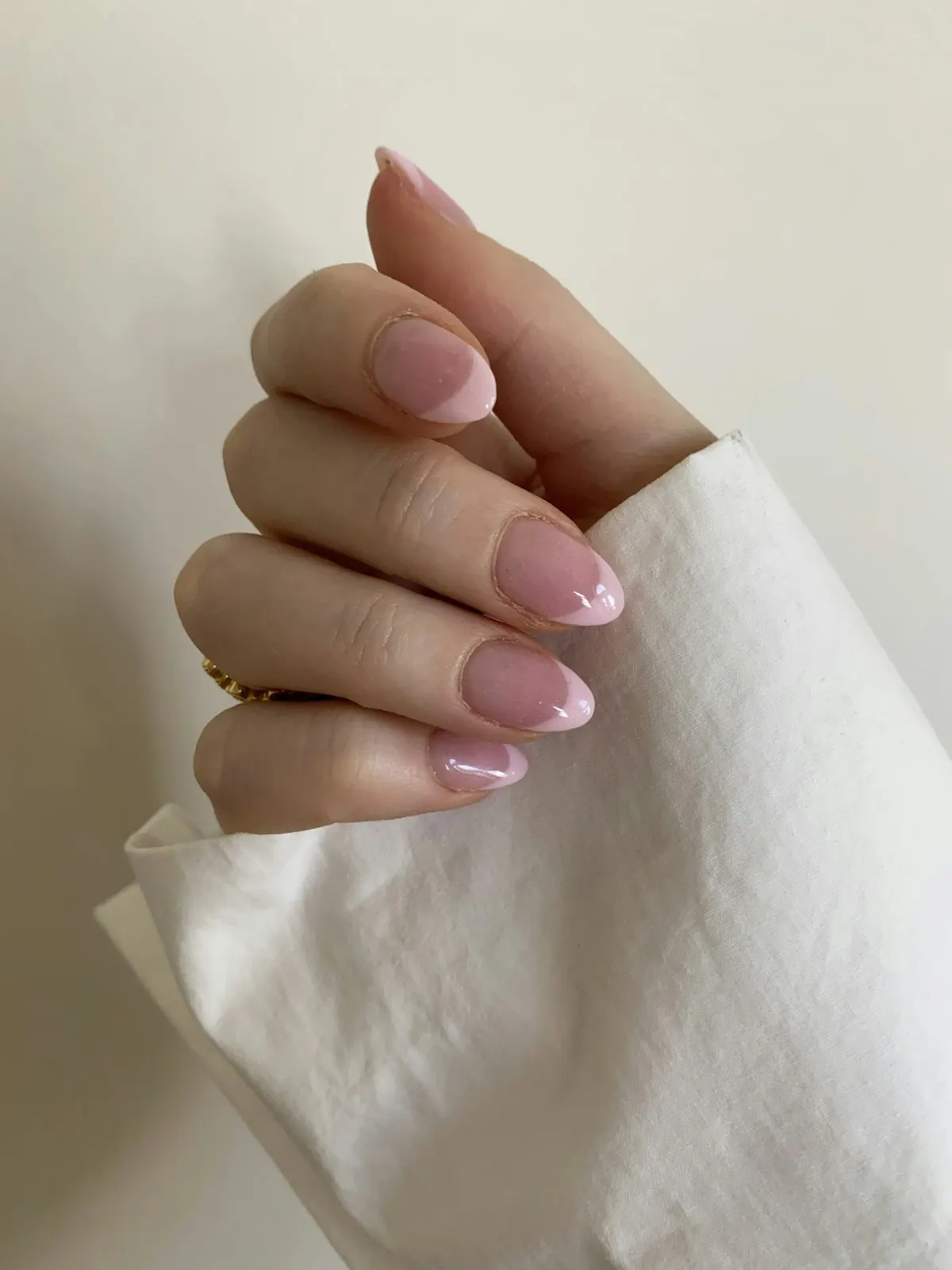 Hand with milky pink almond nails